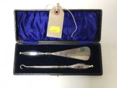 A silver handled button hook and shoe horn in case