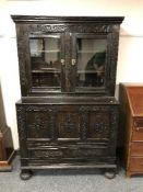 A 19'th Century carved oak coffer, with glazed double-door cupboard above, width 108 cm.
