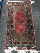 A fringed woollen Turkish rug pink ground