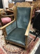 A Continental carved oak wingback easy chair, upholstered in blue velvet.