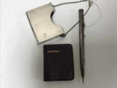 A silver prayer book holder on chain with prayer book and a silver mechanical pencil