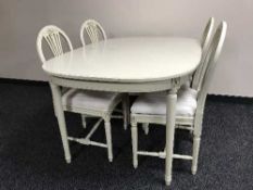 A cream and gilt dining table and four chairs