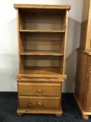 A pine bedside stand and a set of open bookshelves