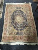 A silk finished fringed rug on blue ground