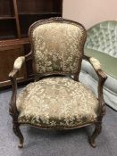 A carved walnut framed armchair in a tapestry fabric