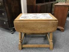 An oak tiled topped drop leaf table