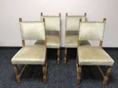 An antique oak dining table and four chairs in beige fabric