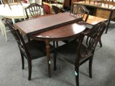 A circular extending table and two leaves plus four shield back chairs