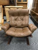 A mid 20th century brown button leather and stained beech armchair