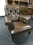 An early 20th century brown button leather armchair