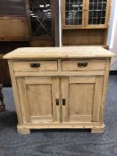 A stripped pine cupboard fitted two drawers