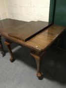 A mahogany Queen Anne style wind out dining table with leaf