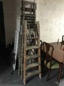 Two sets of folding wooden step ladders and a piece of driftwood