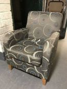 A contemporary armchair in silvered patterned covering