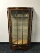 A shaped walnut display cabinet