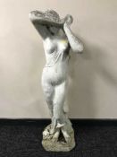 A concrete garden statue of a maiden