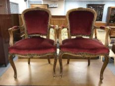 A pair of walnut upholstered armchairs