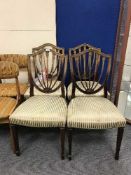 A set of four shield backed dining chairs