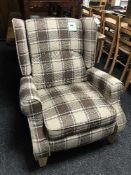 A contemporary reclining armchair in a brown checked print