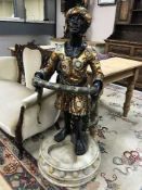 A pair of Blackamoor figures holding snakes,