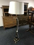 A black and gilt standard lamp on paw feet