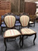 A pair of antique carved mahogany dining chairs in a pink striped fabric