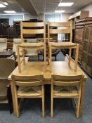 A contemporary extending table and four beech chairs