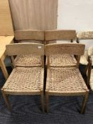 A set of four teak rush seated dining chairs