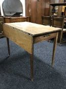 An antique pine drop leaf kitchen table fitted a drawer