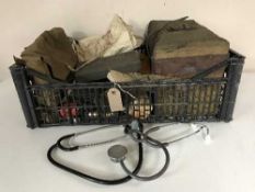 A crate of WWII field first aid kit, surgeons apron, stethoscopes,