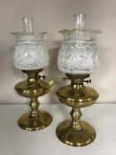 Two brass oil lamps with glass shades and chimneys