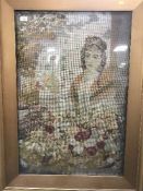 A gilt framed needlework depicting a flower arranger