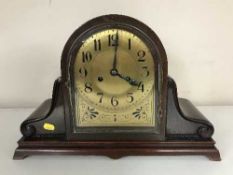 An early twentieth century mahogany domed mantel clock with brass dial