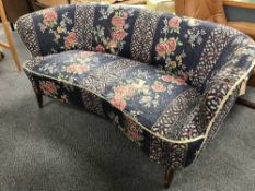 An early 20th century shaped settee in blue floral fabric
