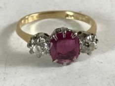 An 18ct gold ruby and diamond three stone ring