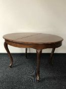 An early 20th century mahogany extending dining table with leaves and five chairs