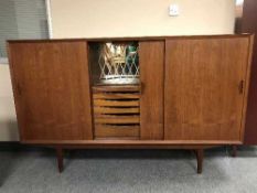 A mid 20th century teak sliding door sideboard