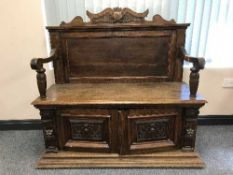 A late 19th century carved oak hall seat