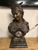 A patinated figural mantel clock with enamel dial,