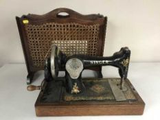 A Singer hand sewing machine together with a mahogany bergere magazine rack