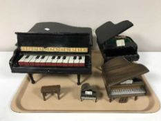 A tray of four miniature Baby Grand pianos one with stool