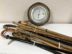 A bundle of walking sticks and umbrellas plus an oak cased barometer