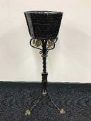 An ornate metal jardiniere on stand with liner