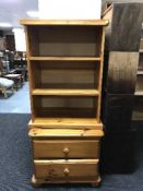 A pine bedside stand and a set of open bookshelves