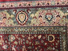 A Persian Tabriz designed carpet on red ground