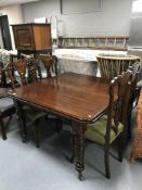 A late Victorian mahogany wind out dining table and a set of Victorian inlaid mahogany dining