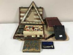 A tray of boxed games compendium, cribbage board, books, papier mache box,