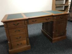 A reproduction twin pedestal partner's desk inset three leather panels