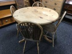 A circular pine table and four chairs