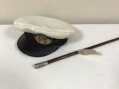 A military swagger stick and a Naval cap with badge